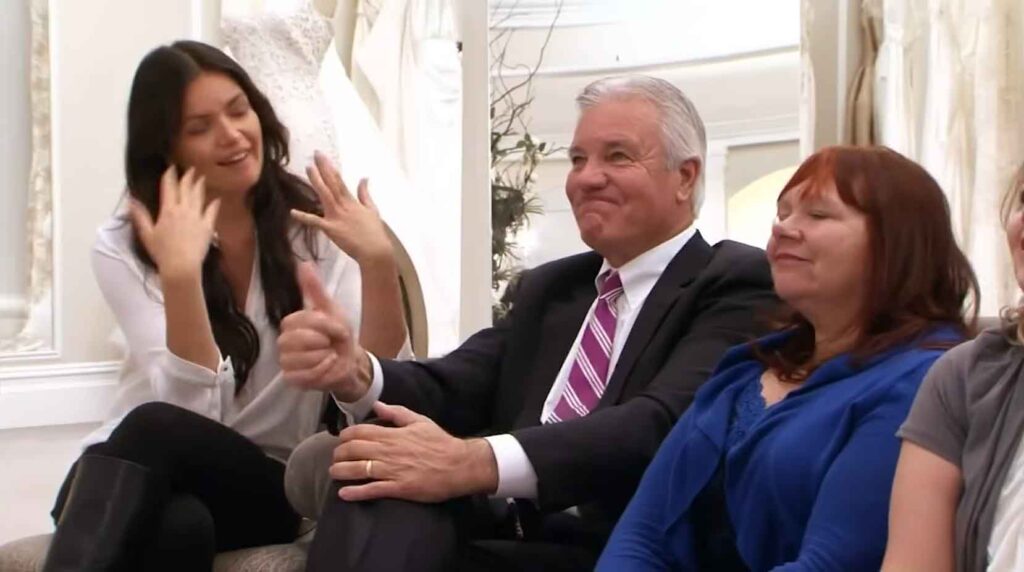 Father and sister crying tears of joy during an emotional bridal fitting appointment.